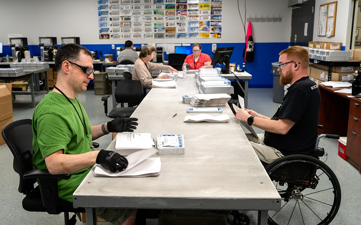 A group of workers handling license plates