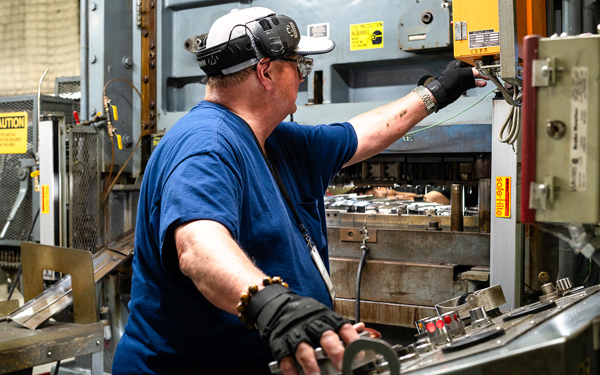 Man running manufacturing equipment.