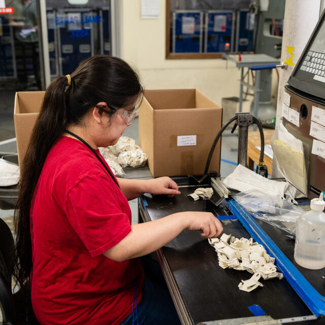 Worker producing parts in Center's Desktop Assembly department