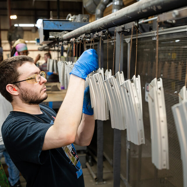Man working on Gun Magazine assembly line